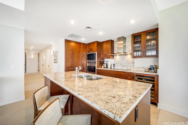 kitchen with wall chimney range hood, stainless steel appliances, wine cooler, a kitchen bar, and light colored carpet