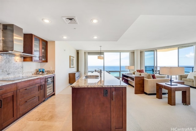 kitchen with a wealth of natural light, wall chimney range hood, and a water view