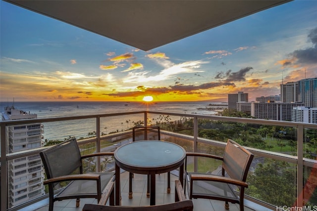 balcony at dusk with a view of the beach and a water view