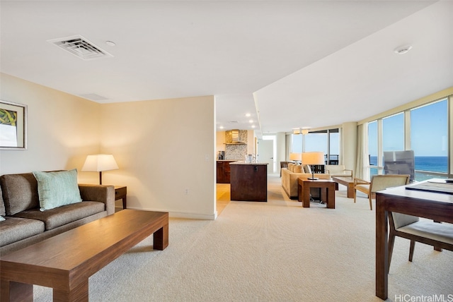 carpeted living room featuring a water view