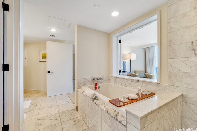 bathroom with a relaxing tiled tub