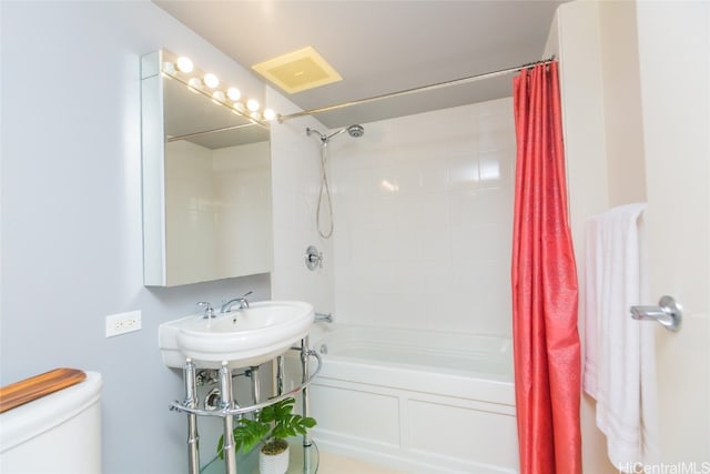 full bathroom featuring toilet, shower / bathtub combination with curtain, and sink