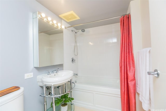 bathroom featuring shower / bathtub combination with curtain and toilet