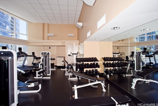 exercise room with a high ceiling and a drop ceiling