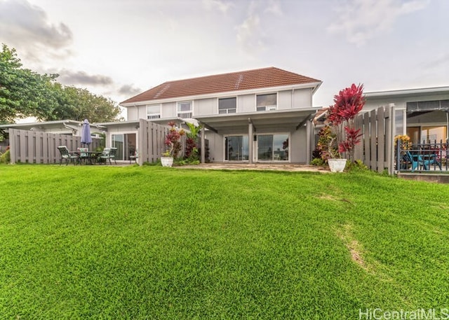 back of house featuring a patio area and a lawn