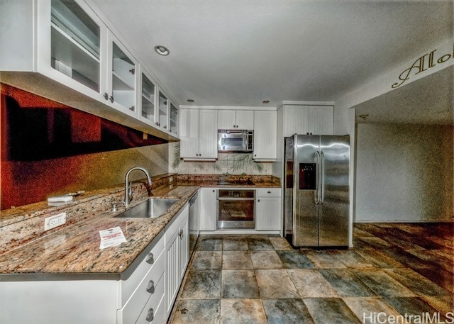 kitchen featuring light stone countertops, sink, appliances with stainless steel finishes, and white cabinets