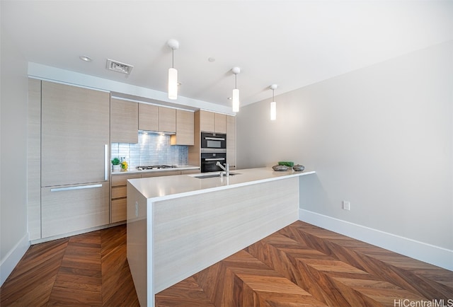 kitchen with light brown cabinets, stainless steel gas cooktop, dark parquet flooring, pendant lighting, and tasteful backsplash