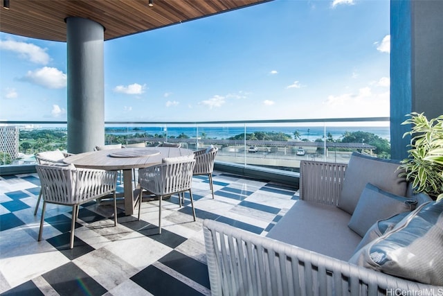 balcony with an outdoor hangout area and a water view