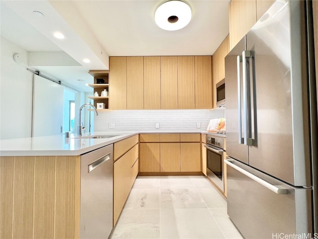 kitchen featuring backsplash, stainless steel appliances, light brown cabinetry, and sink