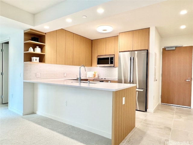 kitchen featuring kitchen peninsula, stainless steel appliances, backsplash, sink, and light tile patterned flooring