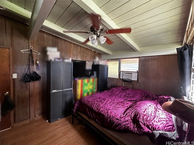 bedroom with cooling unit, hardwood / wood-style floors, ceiling fan, wooden walls, and beam ceiling