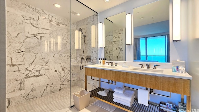 bathroom featuring a tile shower, tile patterned flooring, and vanity