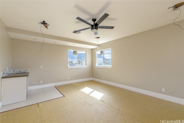 interior space with light tile patterned floors and ceiling fan