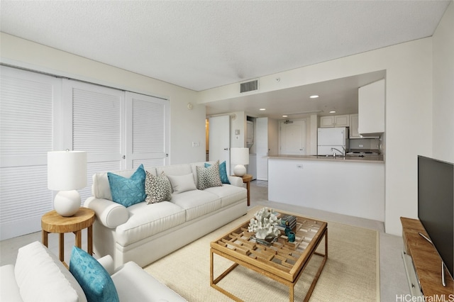 living room with a textured ceiling and light colored carpet