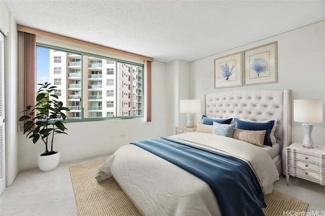 bedroom featuring light carpet and a textured ceiling