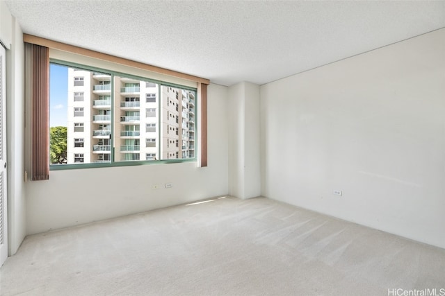 carpeted empty room with a textured ceiling