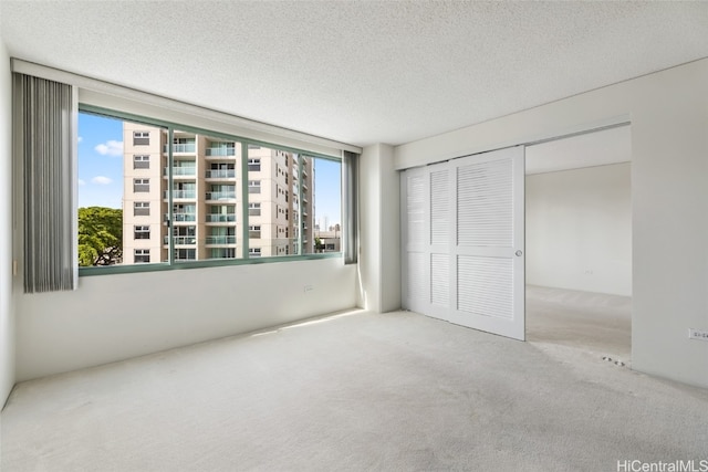 unfurnished bedroom with a closet, a textured ceiling, and carpet flooring