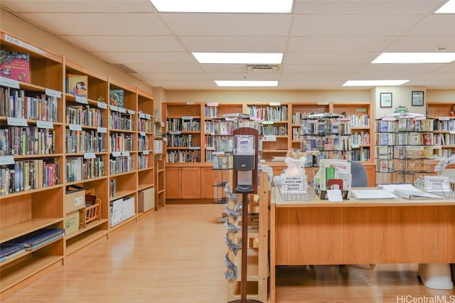 office area with light hardwood / wood-style flooring and a drop ceiling