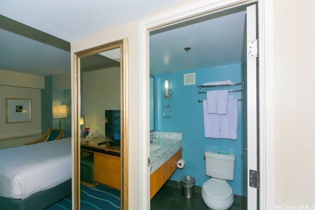 bathroom with toilet, vanity, and tile patterned floors