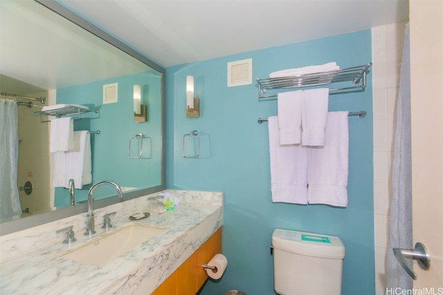 bathroom featuring vanity, curtained shower, and toilet