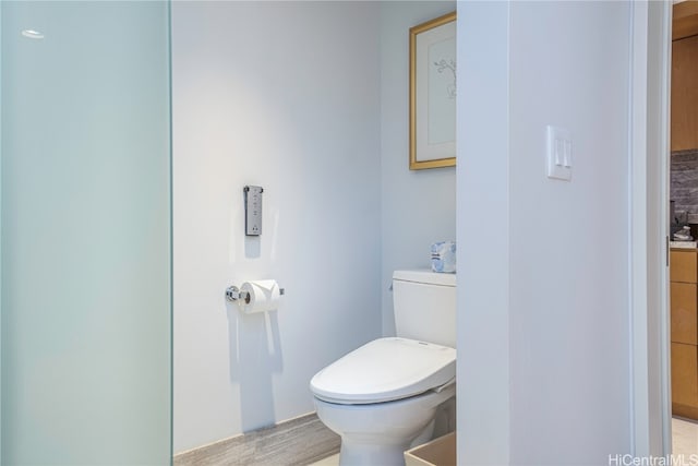 bathroom with toilet and hardwood / wood-style floors