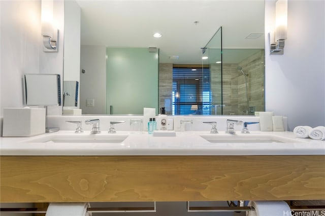 bathroom featuring a shower with door and vanity