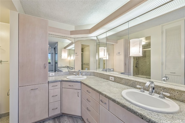 bathroom with vanity, a textured ceiling, a shower with door, and hardwood / wood-style floors