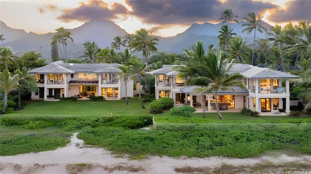 508 N Kalaheo Ave, Kailua, HI 96734 - back of property at dusk with a balcony, a mountain view, a lawn, and a patio area