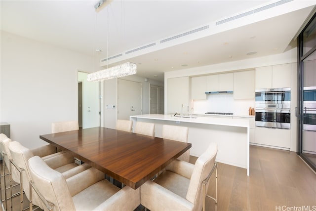 dining space featuring sink and light wood-type flooring