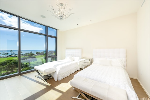 bedroom featuring a water view, hardwood / wood-style flooring, and multiple windows