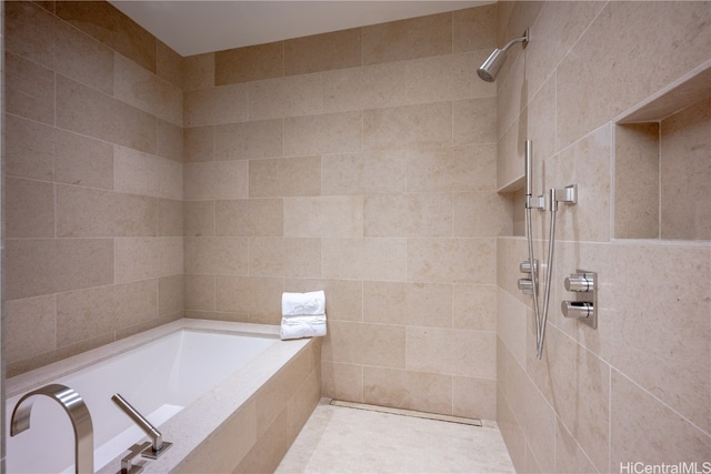 bathroom featuring plus walk in shower and tile walls