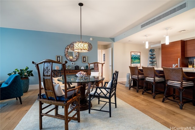 dining area with light hardwood / wood-style flooring and indoor bar