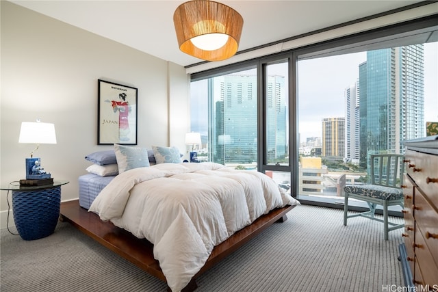 bedroom with multiple windows, carpet floors, and floor to ceiling windows