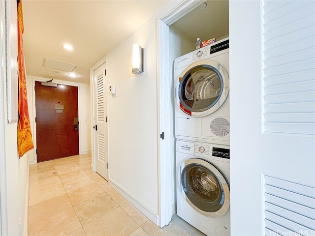 clothes washing area featuring stacked washer / dryer and light tile patterned floors