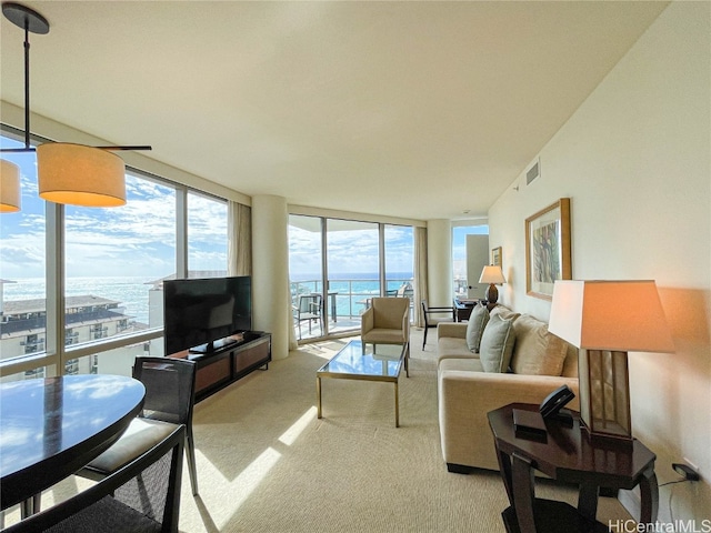 living room with a wealth of natural light, expansive windows, and light colored carpet