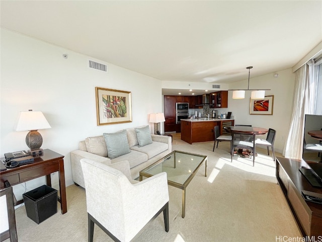 living room featuring light colored carpet, sink, and vaulted ceiling