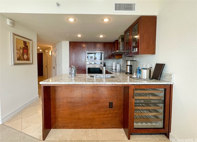 kitchen with stainless steel microwave, wall chimney exhaust hood, kitchen peninsula, wine cooler, and sink