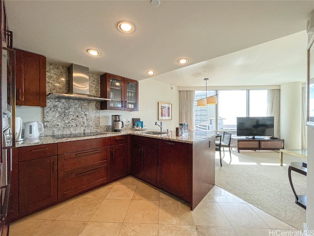 kitchen with sink, kitchen peninsula, black electric cooktop, wall chimney exhaust hood, and light colored carpet