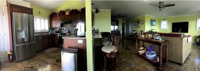 kitchen featuring appliances with stainless steel finishes, a breakfast bar, ornamental molding, and ceiling fan