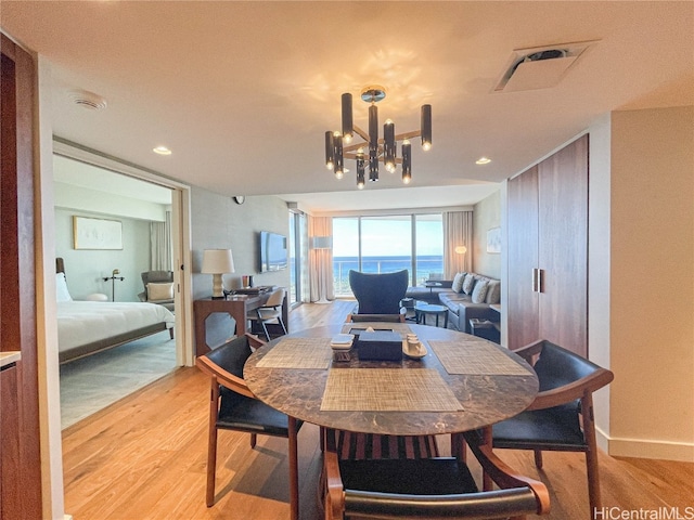 dining space with light hardwood / wood-style floors and a chandelier