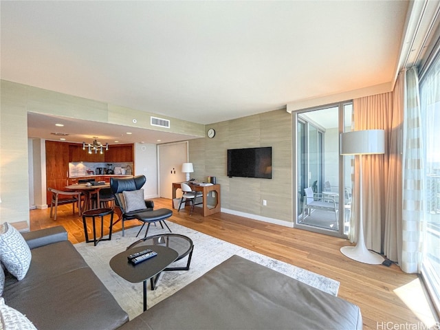 living room with light hardwood / wood-style floors and a chandelier