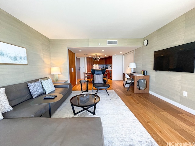 living room with a notable chandelier and light hardwood / wood-style flooring