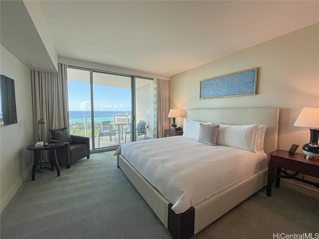 carpeted bedroom featuring access to outside, a wall of windows, and a water view