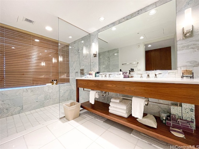 bathroom featuring a tile shower, vanity, tile walls, and tile patterned flooring