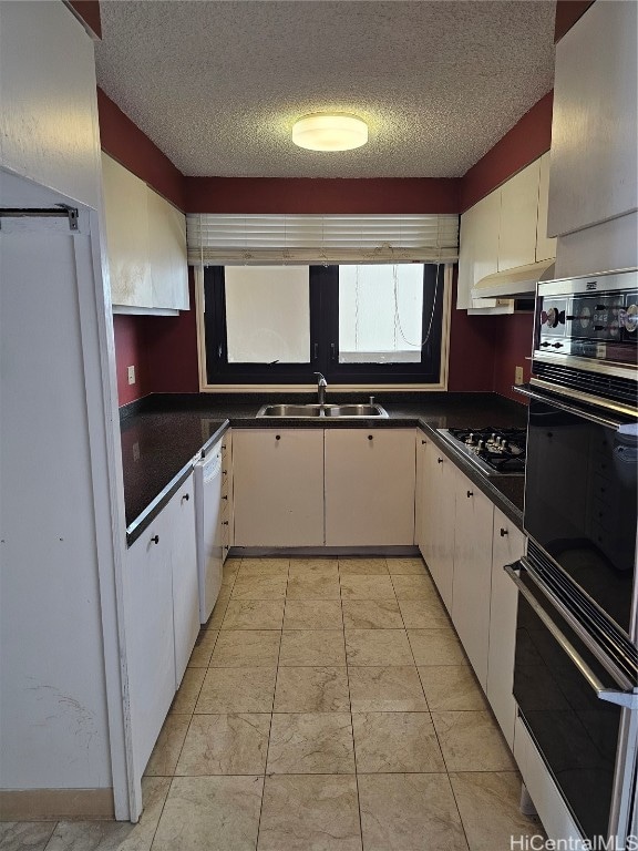 kitchen with sink, black appliances, white cabinetry, and a textured ceiling