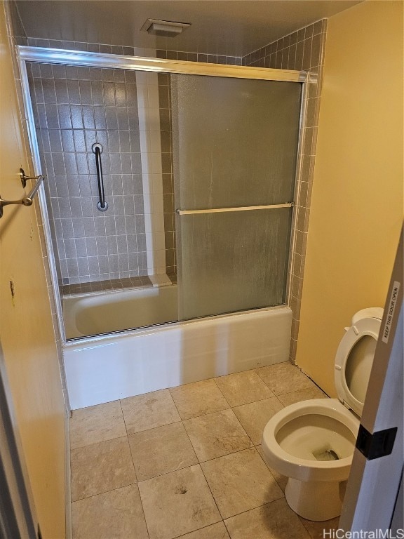 bathroom featuring toilet, shower / bath combination with glass door, and tile patterned flooring