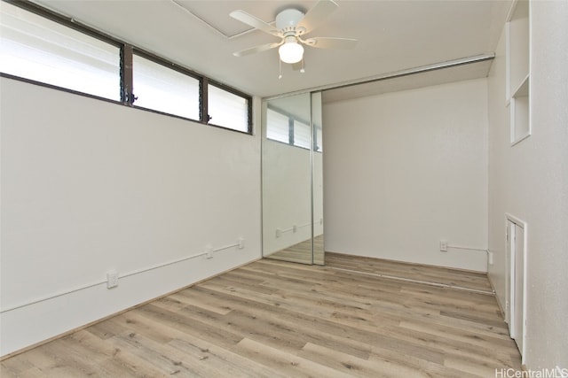 unfurnished bedroom featuring a closet, light hardwood / wood-style floors, and ceiling fan