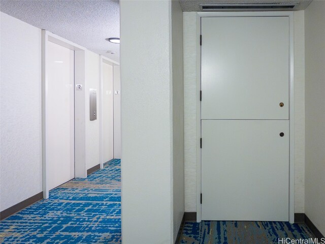 hall featuring a textured ceiling