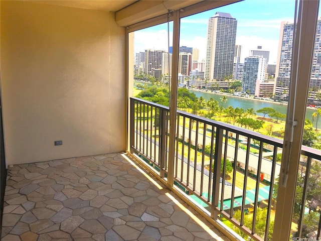 balcony featuring a water view and a city view