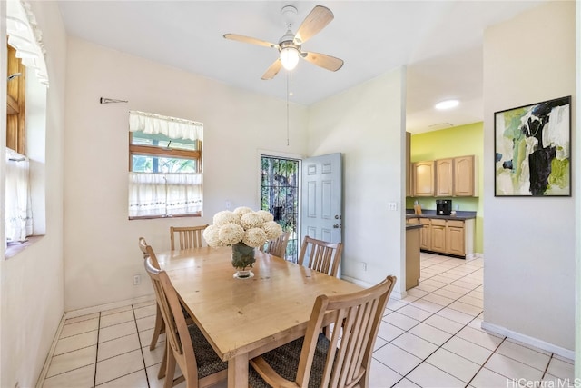 dining space with ceiling fan and light tile patterned flooring